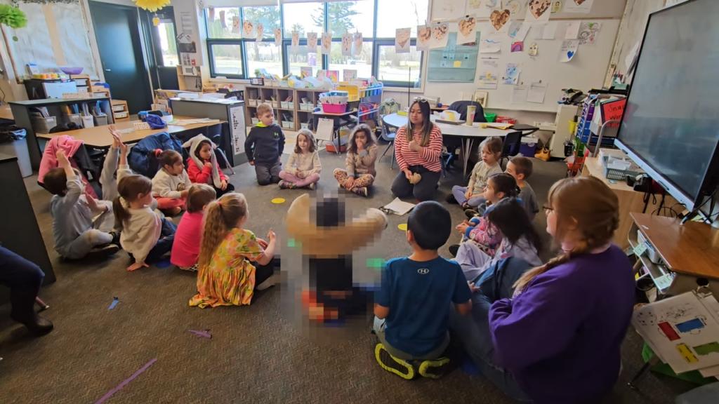 students in a circle with their teacher